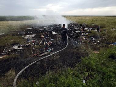 An Emergencies Ministry member works at putting out a fire at the site of a Malaysia Airlines Boeing 777 plane crash in the settlement of Grabovo in the Donetsk region. Reuters.