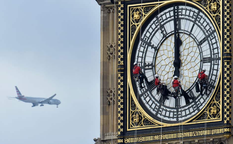 Cleaners abseil down one of the faces of Big Ben, to clean and polish the clock face, above the Houses of Parliament, in central London August 19, 2014. A week has been set aside for the cleaning of what is officially known as the Great Clock, which is set in the Elizabeth Tower. REUTERS