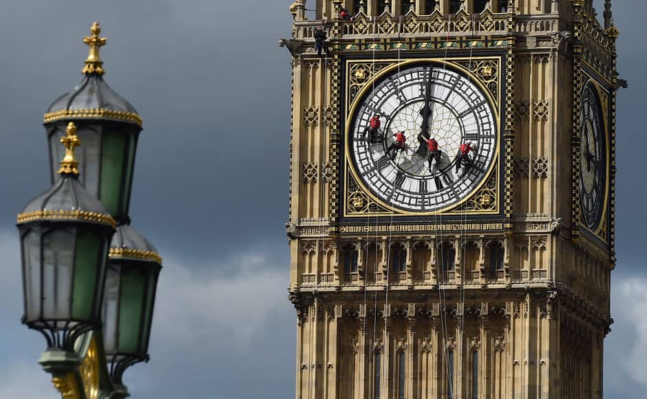 Cleaners abseil down one of the faces of Big Ben, to clean and polish the clock face, above the Houses of Parliament, in central London August 19, 2014. A week has been set aside for the cleaning of what is officially known as the Great Clock, which is set in the Elizabeth Tower. REUTERS