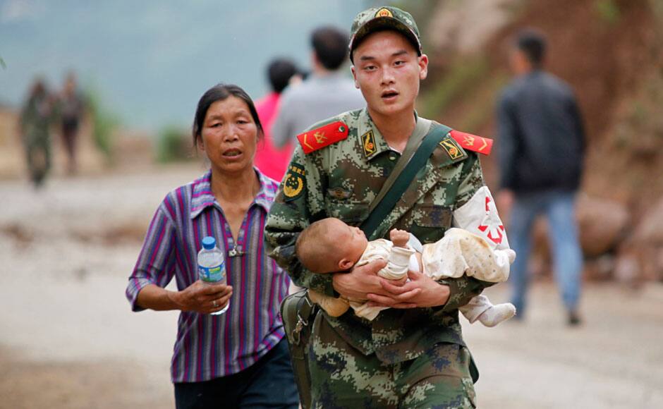 A paramilitary policeman carries a baby in his arms after an earthquake hit Ludian county of Zhaotong, Yunnan province August 3, 2014. The magnitude 6.5 earthquake struck southwestern China on Sunday, killing at least 175 people and leaving more than 180 missing and 1,400 injured in the remote area of Yunnan province, causing thousands of buildings, including a school, to collapse, Xinhua News Agency reported. REUTERS