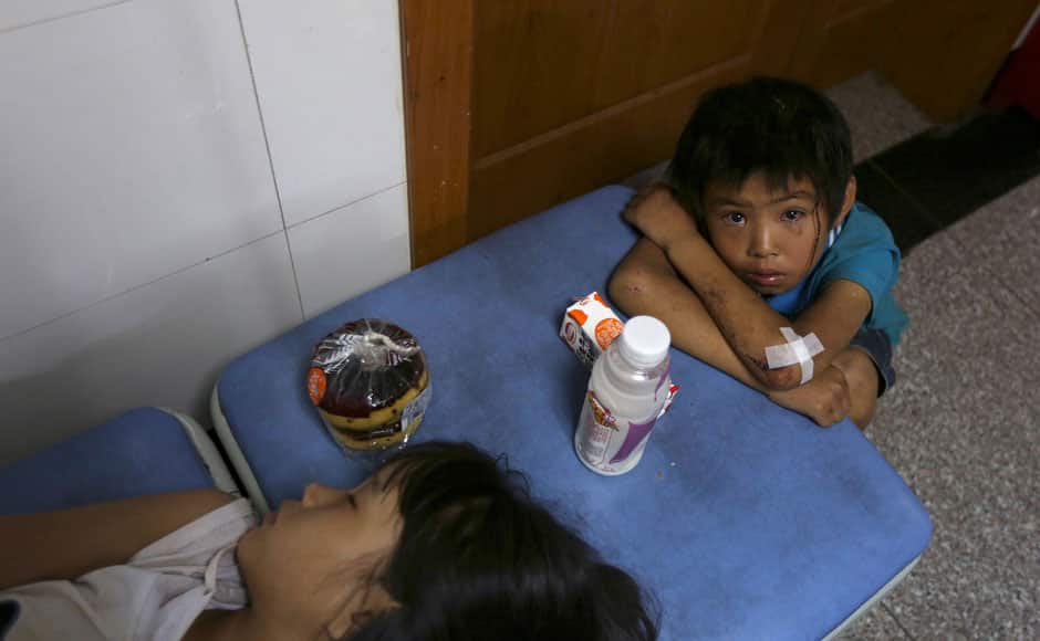A boy cries next to his sister at a hospital after they were injured in an earthquake in Ludian county of Zhaotong, Yunnan province August 3, 2014. A magnitude 6.3 earthquake struck southwestern China on Sunday, killing at least 175 people and leaving more than 180 missing and 1,400 injured in a remote area of Yunnan province, causing thousands of buildings, including a school, to collapse. REUTERS