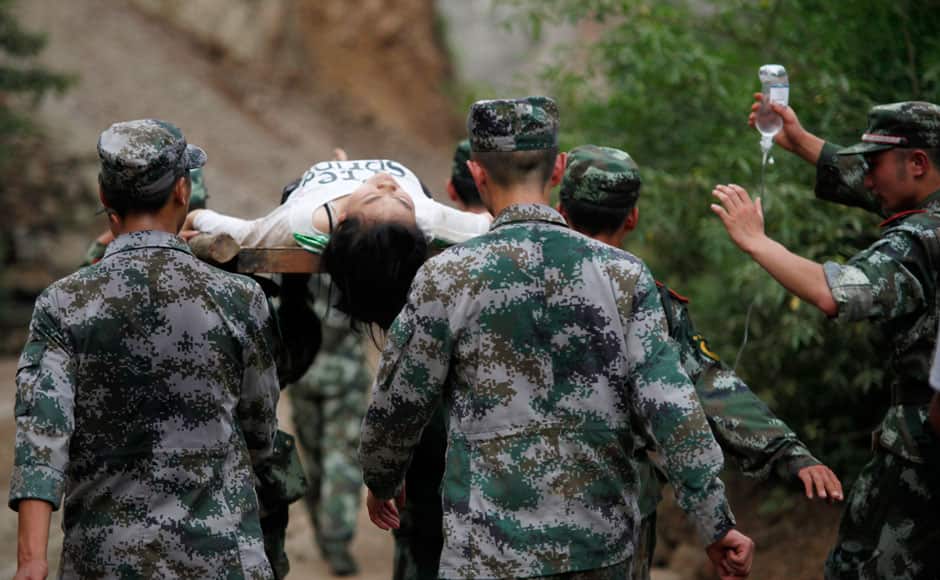 Paramilitary policemen carry an injured woman with a stretcher after an earthquake hit Ludian county of Zhaotong, Yunnan province August 3, 2014. The magnitude 6.5 earthquake struck southwestern China on Sunday, killing at least 175 people and leaving more than 180 missing and 1,400 injured in a remote area of Yunnan province, causing thousands of buildings, including a school, to collapse, Xinhua News Agency reported. REUTERS