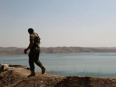 A Kurdish peshmerga fighter patrols near the Mosul Dam at the town of Chamibarakat outside Mosul. AP 