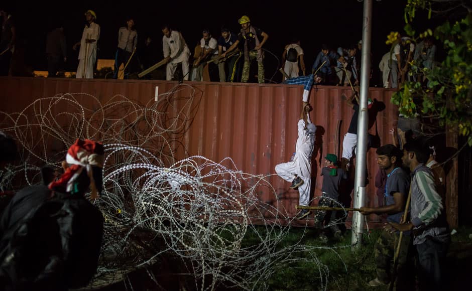 Supporters of Tahir ul-Qadri, Sufi cleric and leader of political party Pakistan Awami Tehreek (PAT), stand on a container barricade while going towards the Prime Minister's house during Revolution March in Islamabad August 30, 2014. Thousands of protesters massed outside the residence of Pakistani Prime Minister Nawaz Sharif on Saturday to demand he step down, after efforts to find a negotiated solution to the country's political crisis failed. Pakistan has been gripped by unrest for more than two weeks, with protest leaders Imran Khan and Tahir ul-Qadri saying they will not back back down unless Prime Minister Nawaz Sharif resigns. On Saturday Sharif once again said he would not go. REUTERS