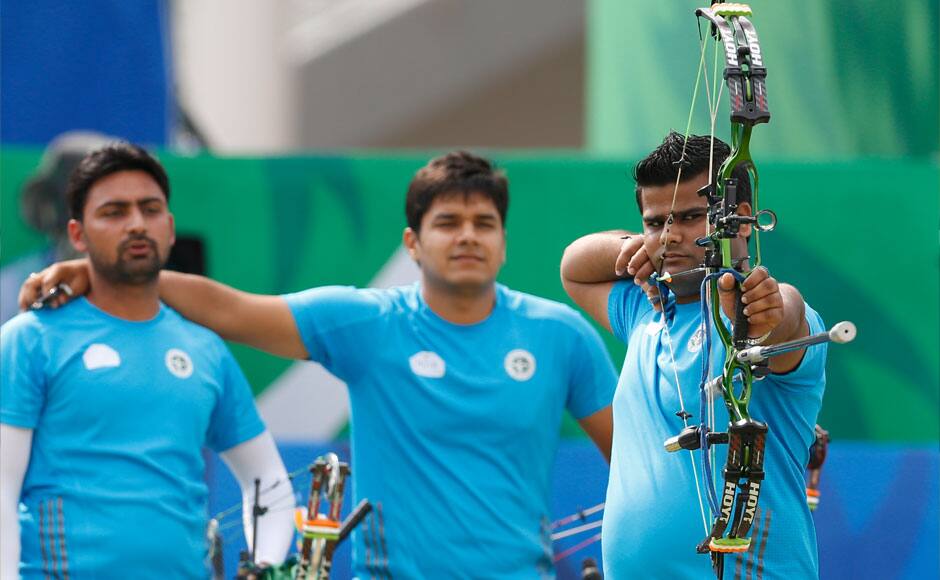 India's team members Sandeep Kumar, Abhishek Verma watch on as Raijat Chauhan takes aim during the compound men's team gold medal archery match at the 17th Asian Games in Incheon, South Korea. AP