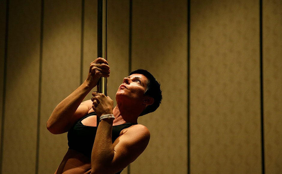 In this Sept. 7, 2014 photo, Heidi Nilsson participates in a workshop at the Pole Expo in Las Vegas. Poles have long been a staple of strip clubs, but many of the attendees at the expo are taking the lead of expo founder Fawnia Dietrich and refining their slinky craft as a workout activity. (AP Photo/John Locher)