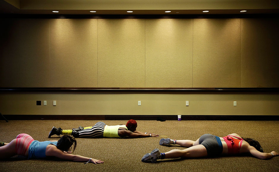 In this Sept. 7, 2014 photo, Torwa Joe, center, teaches a workshop on body movement to Crystaline Brown, left, and Melissa Hein at the Pole Expo in Las Vegas. The expo, held at the Palms Casino, offered workshops on everything from strength conditioning to lap dancing. (AP Photo/John Locher)