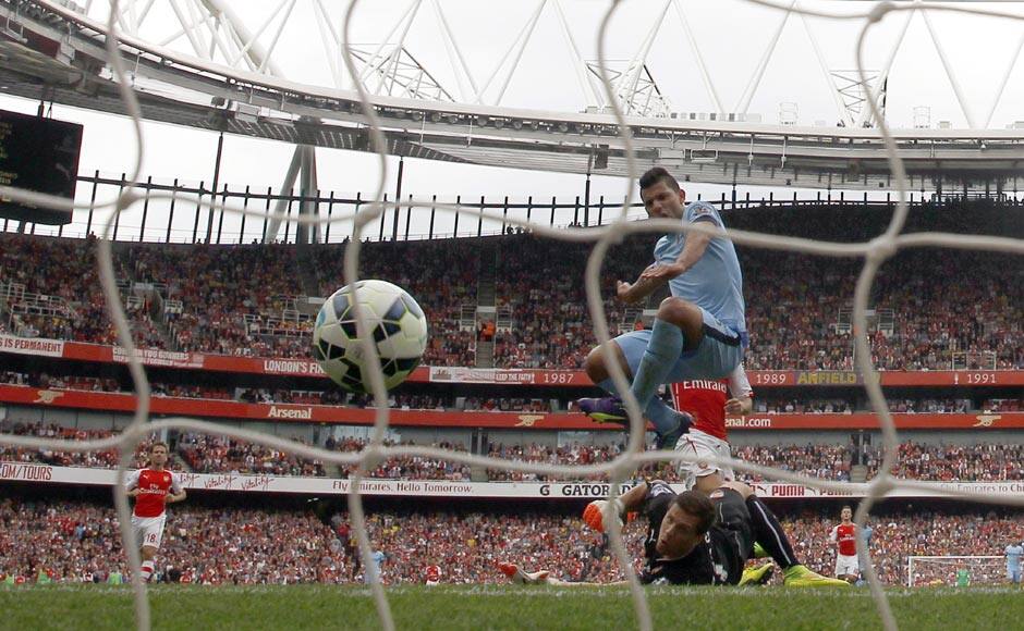 Sergio Aguero (R) scores Manchester City's first goal against Arsenal at the Emirates stadium. The match ended in an entertaining 2-2 draw. Reuters