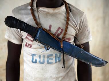 An Anti-Balaka Christian fighter stands on the front of a looted Muslim store in Guen, Central African Republic. AP Photo