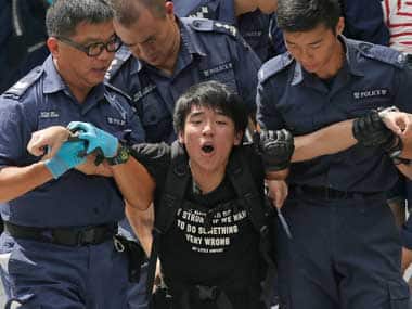 A student is taken away by policemen at the government headquarters in Hong Kong. AP 
