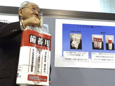 Satoshi Kurosaki, an industry executive who is leading the toilet pear campaign, shows the emergency stock toilet paper at Ministry of Economy, Trade and Industry during an event marking Monday’s national disaster prevention day in Tokyo. AP