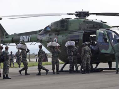 Indian army soldiers load onto a helicopter relief material for flood victims at an air force base in Srinagar. AP 