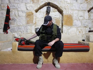 Jamil, a Lebanese Catholic fighter, poses with his weapon while resting inside a safe-house on the outskirts of Arsal, Lebanon. Reuters image