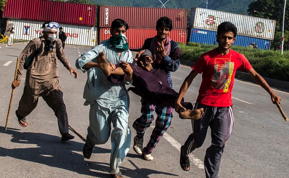Supporters of Tahir ul-Qadri, Sufi cleric and leader of political party Pakistan Awami Tehreek (PAT), carry an injured fellow protester during the Revolution March in Islamabad August 31, 2014. Thousands of protesters massed outside the residence of Pakistani Prime Minister Nawaz Sharif on Saturday to demand he step down, after efforts to find a negotiated solution to the country's political crisis failed.Pakistan has been gripped by unrest for more than two weeks, with protest leaders Imran Khan and Tahir ul-Qadri saying they will not back back down unless Prime Minister Nawaz Sharif resigns. On Saturday Sharif once again said he would not go. REUTERS