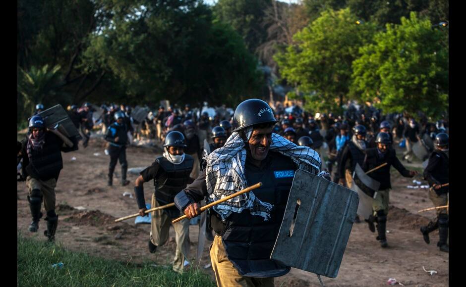 Riot police run away from Supporters of Tahir ul-Qadri, Sufi cleric and leader of political party Pakistan Awami Tehreek (PAT), during the Revolution March in Islamabad August 31, 2014. Thousands of protesters massed outside the residence of Pakistani Prime Minister Nawaz Sharif on Saturday to demand he step down, after efforts to find a negotiated solution to the country's political crisis failed.Pakistan has been gripped by unrest for more than two weeks, with protest leaders Imran Khan and Tahir ul-Qadri saying they will not back back down unless Prime Minister Nawaz Sharif resigns. On Saturday Sharif once again said he would not go. REUTERS