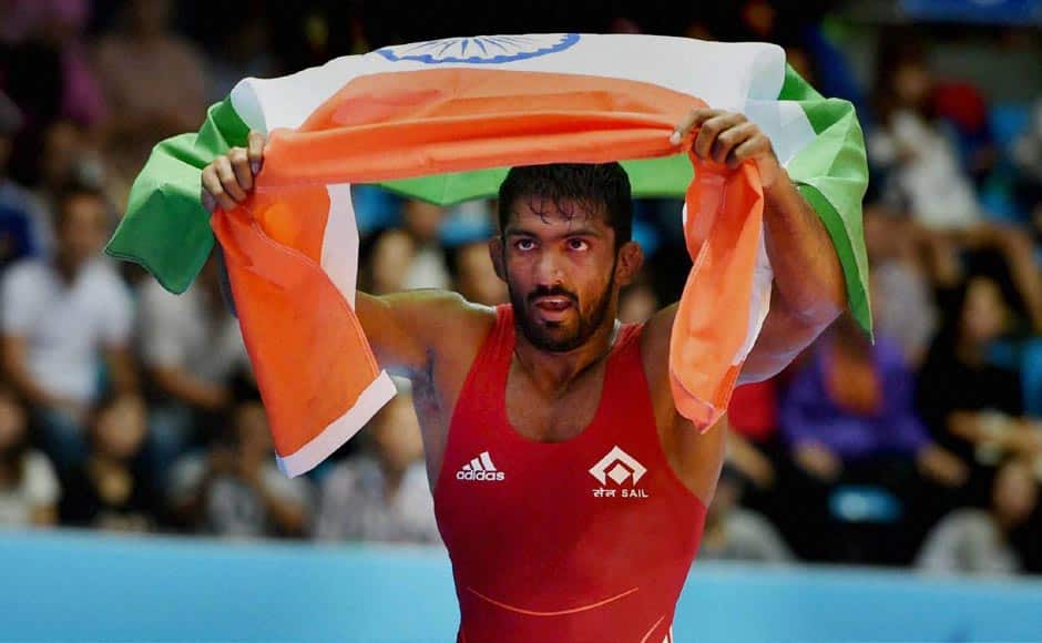 India's Yogeshwar Dutt holds the tricolour after defeating Tajikistan's Zalimkhan Yusupov, winning gold medal in the men's 65 kg freestyle wrestling match at Dowon Gymnasium Stadium. Yogeshwar propelled India into top 10 in the Asian Games with this historic gold. PTI