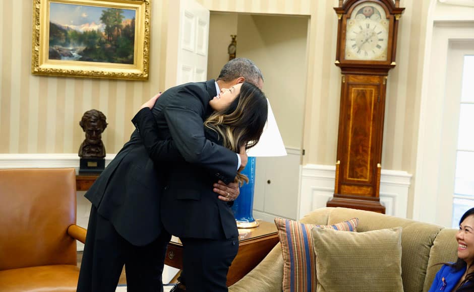 U.S. President Barack Obama hugs Dallas nurse Nina Pham as her mother Diane sits at the Oval Office in Washington, October 24, 2014. Obama met Pham in the Oval Office shortly after her release from a nearby hospital after recovering from the virus. Pham, who contracted the disease while treating a man who later died of Ebola in a Dallas hospital, had been undergoing treatment at the National Institutes of Health in Bethesda, Maryland, since Oct. 16. REUTERS