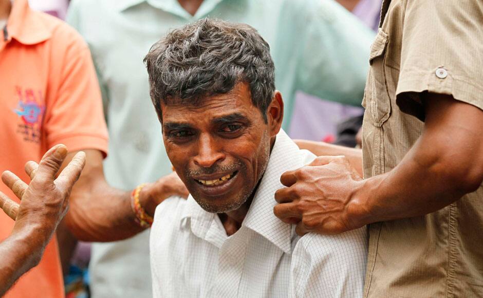 A Sri Lankan man cries for his missing relatives at the site of a mudslide at the Koslanda tea plantation in Badulla district, about 220 kilometers (140 miles) east of Colombo, Thursday, Oct. 30, 2014. Disaster Management Minister Mahinda Amaraweera estimated the number of dead in Wednesday's disaster would be fewer than 100, although villagers said the figure could easily exceed 200. (AP Photo/Eranga Jayawardena)