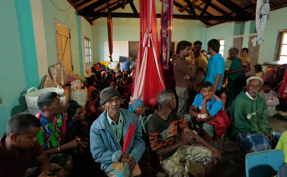Sri Lankan mudslide survivors sit at a relief center set up in a school in Punagala in Badulla district, about 140 miles (220 kilometers) east of Colombo, Sri Lanka, Thursday, Oct.30, 2014. Hundreds of desperate Sri Lankan villagers clawed through the wreckage of a deadly landslide Thursday, defying police orders after a top disaster official said there was no chance of finding more survivors in the broken red earth of the high-elevation tea plantation. There were conflicting reports of how many people were missing in the slide, which struck Wednesday morning in the island nation's central hills.(AP Photo/Eranga Jayawardena)