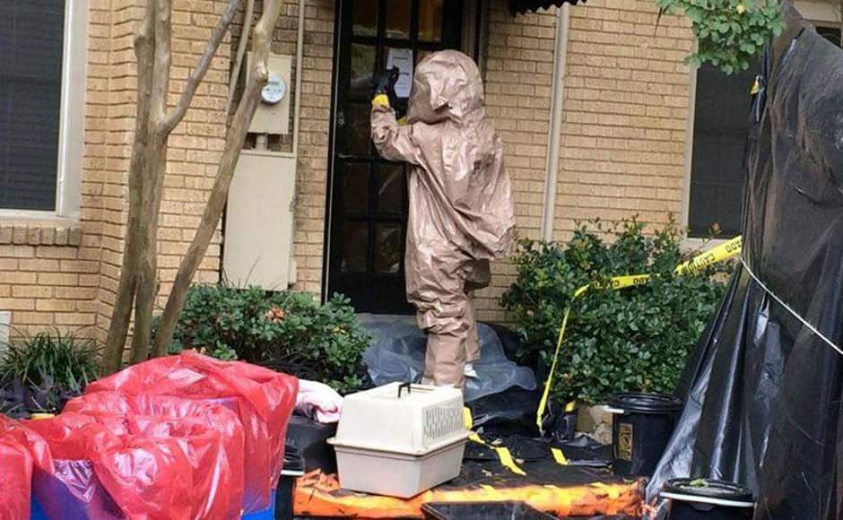 A man wearing a hazardous material suit prepares to remove a pet dog named Bentley from the home of a nurse infected with Ebola, in this handout picture released by the City of Dallas, Texas, October 13, 2014. 