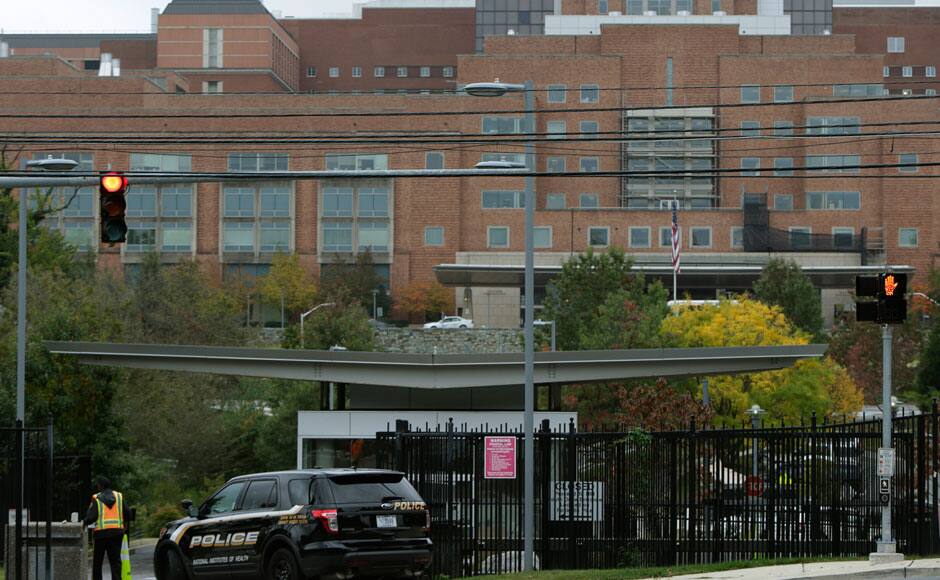 Security personnel guard a patient's entrance at the National Institutes of Health in Bethesda, Maryland October 16, 2014. Nina Pham, the first Texas nurse to be diagnosed with Ebola after treating a Liberian man at a Dallas hospital, is being moved to the National Institutes of Health outside Washington, the agency said on Thursday. Pham, who was being cared for at Texas Health Presbyterian Hospital, will be transferred to an isolation unit at Bethesda, Maryland-based NIH on Thursday evening, NIH's Dr. Anthony Fauci told lawmakers at a congressional hearing on the handling of the virus in the United States. REUTERS