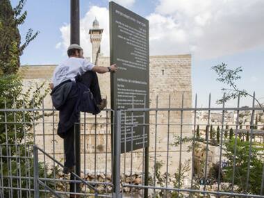 A right-wing Israeli tries to jump a barrier to gain access to the al-Aqsa mosque compound, Islam's third holiest site, but also the most sacred spot for Jews. AFP