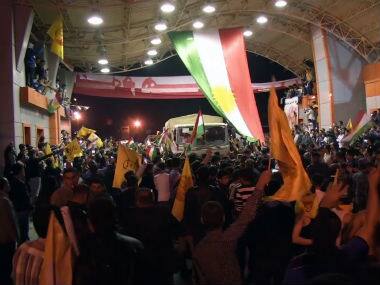 In this image taken from video, people welcome peshmerga soldiers as they arrive at the Ibrahim Khalil border entrance in Zakho, Iraq. AP 
