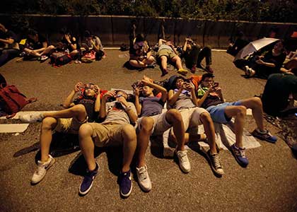 Student protesters rest as thousands occupy a main thoroughfare in Hong Kong. Hong Kong's leader refused to meet with pro-democracy demonstrators by their midnight deadline. Associated Press