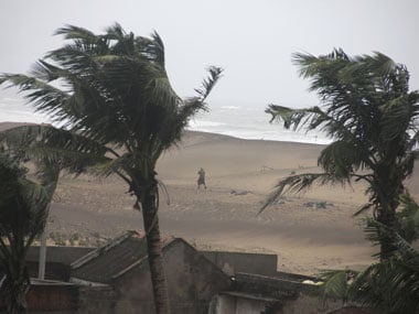A man walks as strong winds blow along a beach in Gopalpur in Ganjam district, Odisha. Reuters