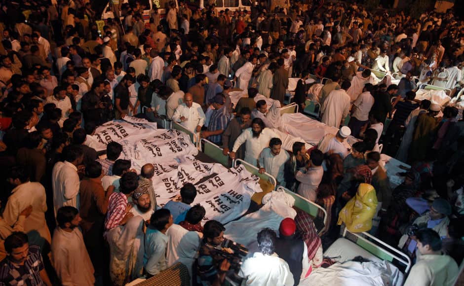 Pakistani relatives gather beside the covered bodies of victims who were killed in suicide bomb attack in Wagah border near Lahore November 2, 2014. At least 45 people were killed on Sunday when a suicide bomber blew himself up on the Pakistani-Indian border, police said, just after a daily ceremony when troops from both sides simultaneously lower the two nations' flags. REUTERS