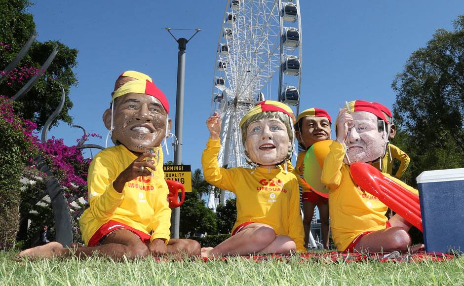 Demonstrators wearing large caricature heads of World leaders, from left, US President Barack Obama, German Chancellor Angela Merkel and British Prime Minister David Cameron pose for a photo dressed as life guards ahead of the G-20 summit in Brisbane, Australia, Friday, Nov. 14, 2014. Oxfam is calling for world leaders attending the summit to address inequality. AP