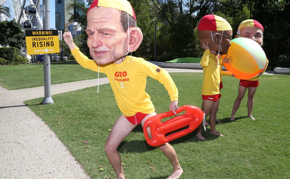 Demonstrators wearing large caricature heads of World leaders, from left, Australian Prime Minister Tony Abbott, South African President Jacob Zuma and Indian Prime Minister Narendra Modi pose for a photo dressed as life guards ahead of the G-20 summit in Brisbane, Australia, Friday, Nov. 14, 2014. Oxfam is calling for world leaders attending the summit to address inequality. AP