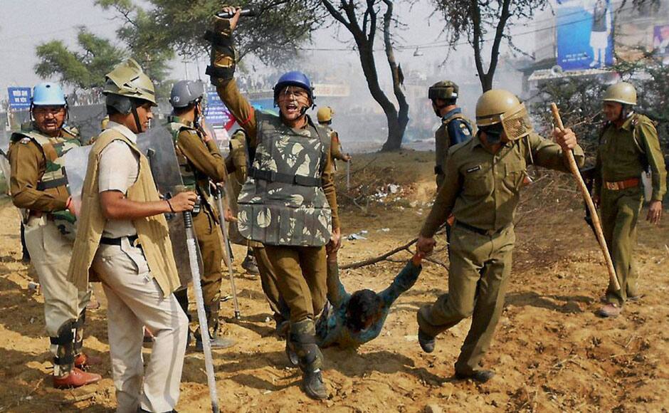 Hisar: Security personnel drag away a follower of Sant Rampal during a clash outside Satlok Ashram in Hisar on Tuesday. Supporters of Rampal indulged in clashes with the police to resist his arrest. PTI