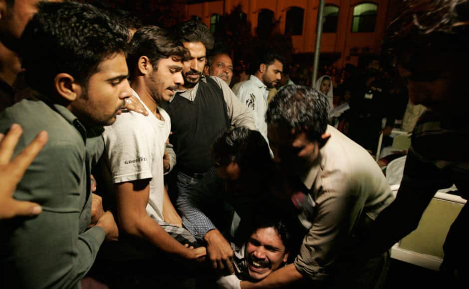 A Pakistani man comforted by others while mourning the death of a relative who was killed in suicide bomb attack in Wagah border near Lahore November 2, 2014. At least 45 people were killed on Sunday when a suicide bomber blew himself up on the Pakistani-Indian border, police said, just after a daily ceremony when troops from both sides simultaneously lower the two nations' flags. REUTERS