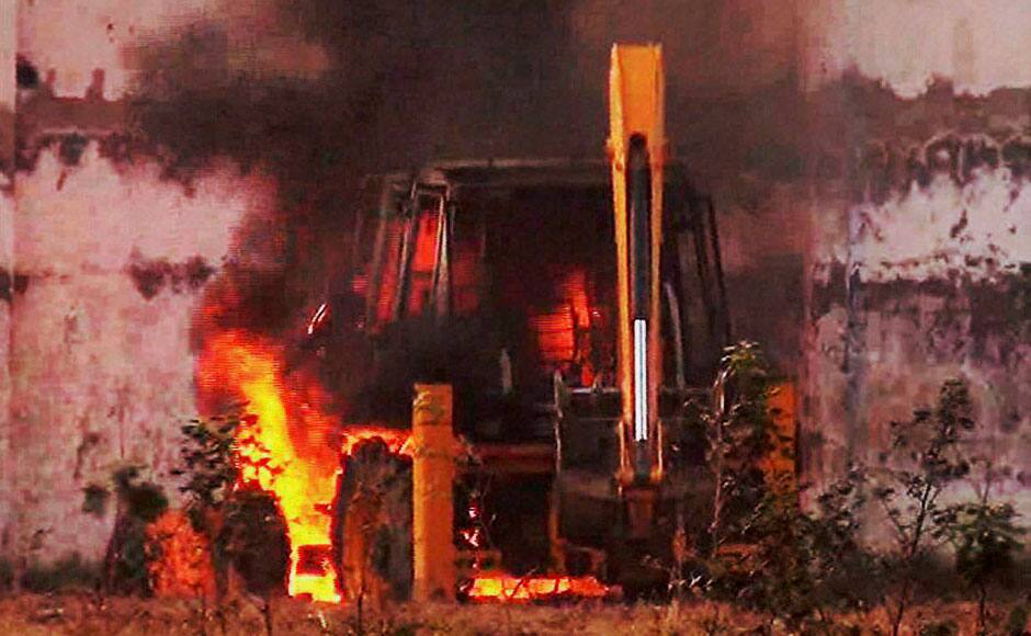 Hisar: A JCB machine burns during violent clash between Police and Sant Rampal’s followers at Satlok Ashram in Hisar on Tuesday. Supporters of Rampal indulged in clashes with the police to resist his arrest. PTI 