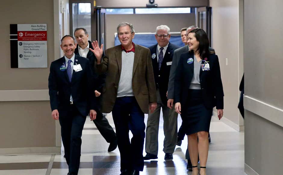 In this photo provided by Texas Health Resources, former President George W. Bush walks into Texas Health Presbyterian Hospital in Dallas, Friday, Nov. 7, 2014, where he visited with caregivers. Bush has marked the end of the Ebola crisis in Dallas by visiting the hospital where a man died of the disease and two nurses became infected. (AP Photo/Texas Health Resources)