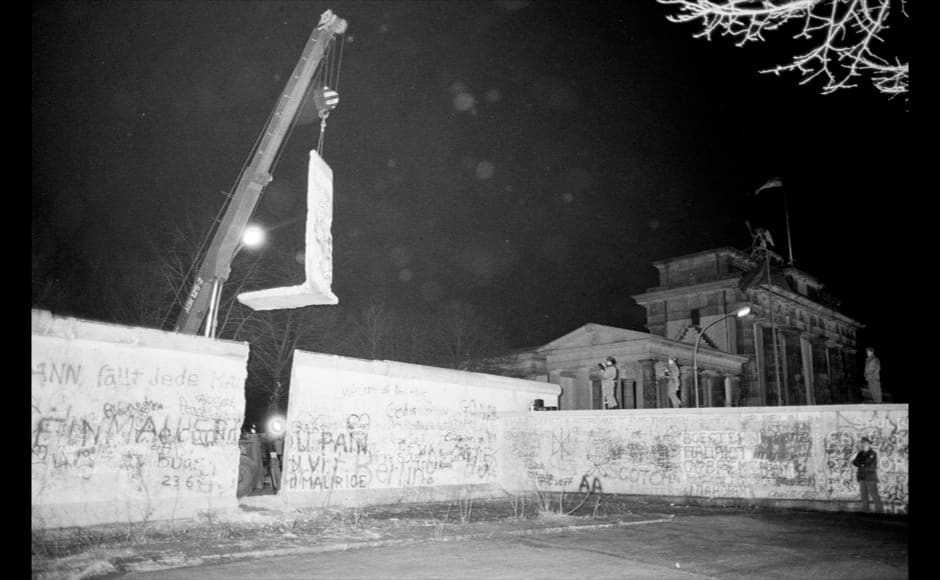 The first section of the Berlin Wall to be dismantled by East Germany is lifted by a crane near the Brandenburg Gate in East Berlin, December 22, 1989. REUTERS/Fabrizio Bensch (GERMANY) - RTR25OWQ