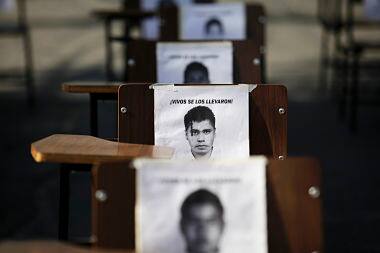 School desks with the photographs of the 43 missing students. Reuters