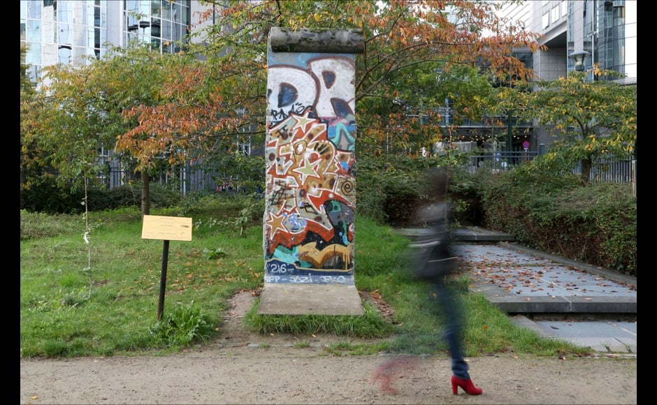 A woman walks past a piece of the Berlin Wall, which was from Potsdamer Platz, in a park outside the European Parliament in Brussels October 31, 2014. On November 9, Germany will celebrate the 25th anniversary of the fall of the Berlin Wall. To mark the event Reuters Photographers around the world captured images of segments of the wall, which are kept as monuments in many countries from Taiwan to South Africa and Costa Rica. The Berlin Wall, which divided West Berlin from the communist East after it was built in 1961, was the most potent symbol of the Cold War. At least 136 people were killed or died at the Wall, most of them while trying to escape. On November 9, 1989, following huge protests in East Berlin the wall was breached and thousands of people poured into West Berlin. Picture taken October 31, 2014. REUTERS/Francois Lenoir (BELGIUM - Tags: SOCIETY ANNIVERSARY CONFLICT) ATTENTION EDITORS - PICTURE 18 OF 32 FOR WIDER IMAGE STORY 'THE BERLIN WALL AROUND THE WORLD' SEARCH '25 BERLIN' FOR ALL IMAGES - RTR4CLPC