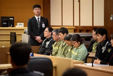 Sewol ferry captain Lee Joon-seok sits with crew members at the start of the verdict proceedings in a court room in Gwangju. Reuters
