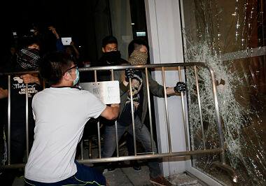 Masked pro-democracy protesters try to break into the Legislative Council. Reuters