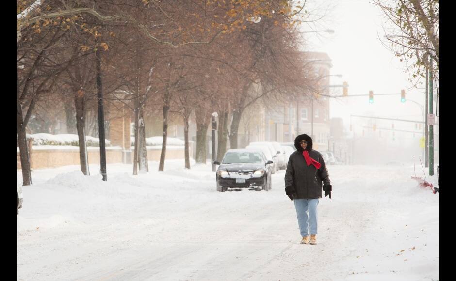 A woman walks down the middle of the street through the blowing snow in Buffalo, New York, November 19, 2014. An autumn blizzard dumped a year's worth of snow in three days on Western New York state, where five people died and residents, some stranded overnight in cars, braced for another pummeling expected later on Wednesday. REUTERS