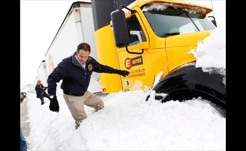 New York Governor Andrew Cuomo climbs over snow piled on the highway after talking with a stranded trucker on interstate I-190 while surveying an area in West Seneca, New York November 19, 2014. Cuomo and other government officials viewed part of the thruway where several trucks and motorists were stranded after an autumn blizzard dumped a year's worth of snow on western New York state. Five people died and residents, some stranded overnight in cars, braced for another pummelling expected later on Wednesday. REUTERS
