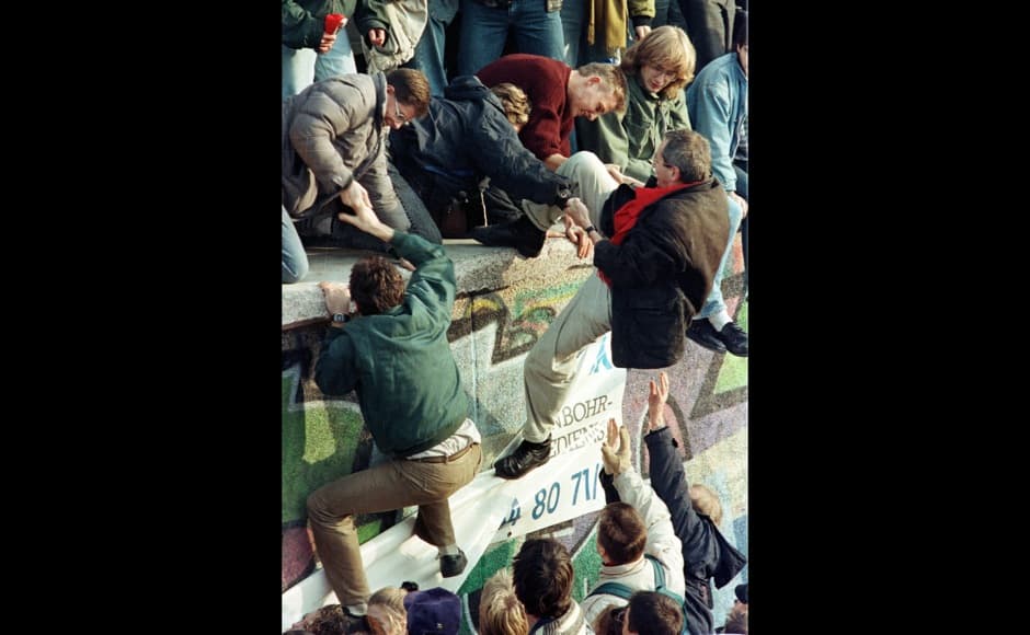 FILE PHOTO 10NOV89 - East German citizens help each other climb the Berlin Wall at the Brandenburg gate after the opening of East German borders in this early November 10, 1989 file photo. The tenth anniversary of the fall of the Berlin Wall occurs November 9, 1999. FAB/CLH/ - RTRRZ8S
