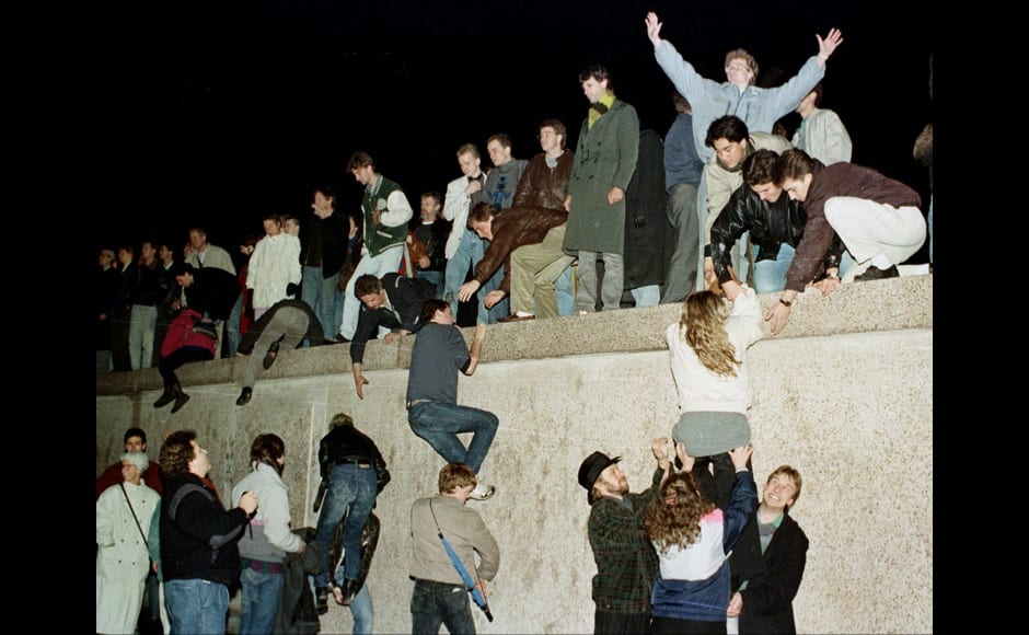FILE PHOTO 10NOV89 - East German citizens climb the Berlin wall at the Brandenburg Gate as they celebrate the opening of the East German border in this November 10, 1989 file photo. The 10th anniversary off the 