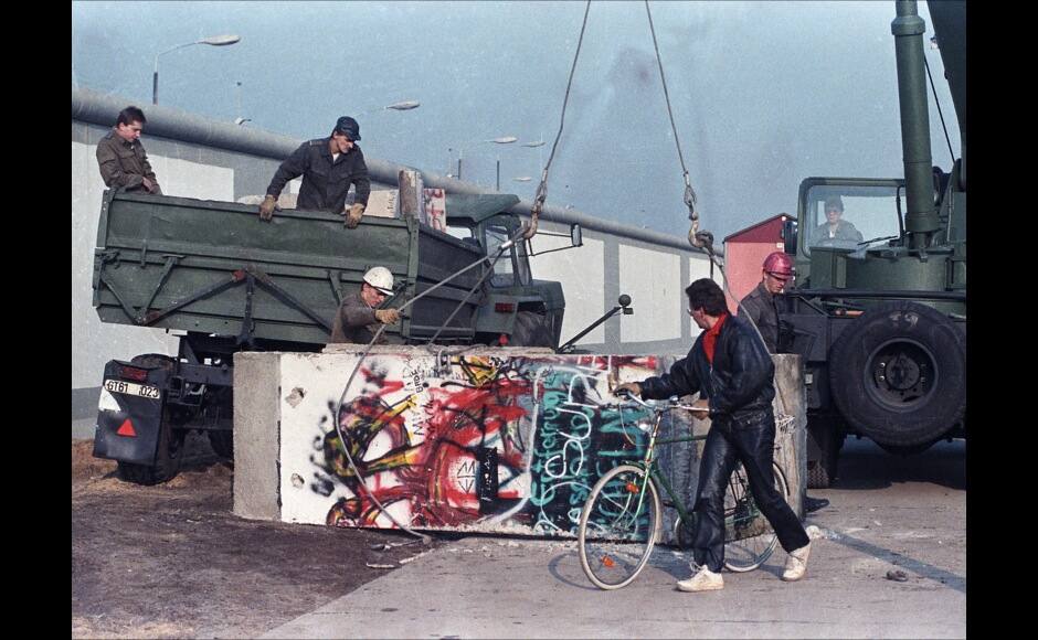 East German workers remove concrete parts of the Berlin Wall and load them onto trucks at the recently opened border crossing point at Potsdam Platz November 14, 1989. Reuters/Wolfgang Rattay BEST QUALITY AVAILABLE - RTX5YI3