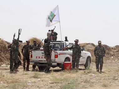 Shi'ite military men shout anti-Islamic State slogans. Reuters