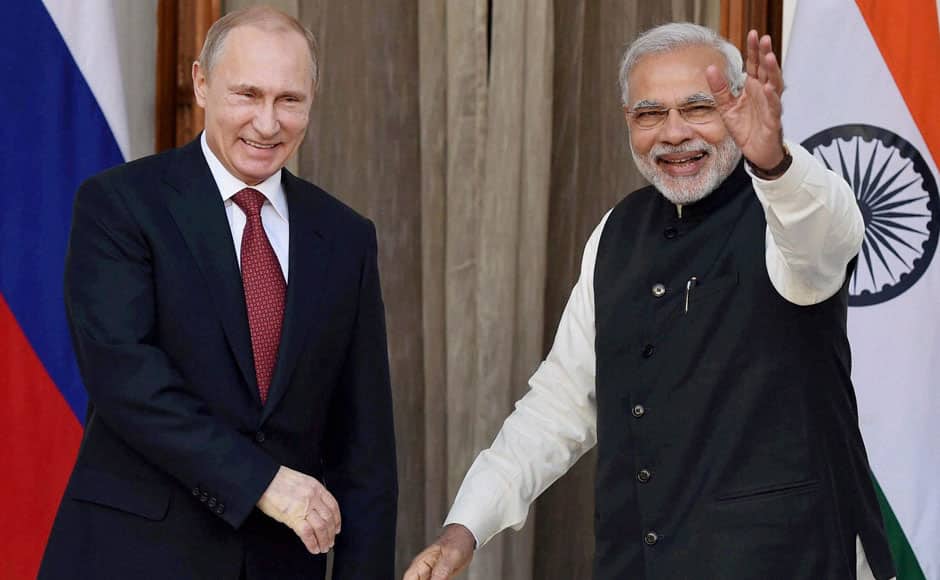 Indian Prime Minister Narendra Modi, right, waves as he poses with Russian President Vladimir Putin during a photo opportunity before a meeting New Delhi, India, Thursday, Dec. 11, 2014. Putin was holding talks with Indian leaders Thursday to strengthen trade and energy cooperation with Asia's third-largest economy as Western sanctions threaten to push his country's economy to the brink of a recession. (AP Photo/Press Trust of India) INDIA OUT