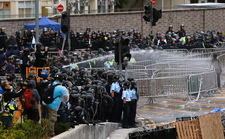Riot police use a water cannon to disperse protesters during clashes outside the government headquarters in Hong Kong December 1, 2014. Hong Kong police baton-charged and pepper-sprayed thousands of pro-democracy demonstrators in the early hours of Monday who were trying to encircle government headquarters, defying orders to retreat after more than two months of protests. REUTERS