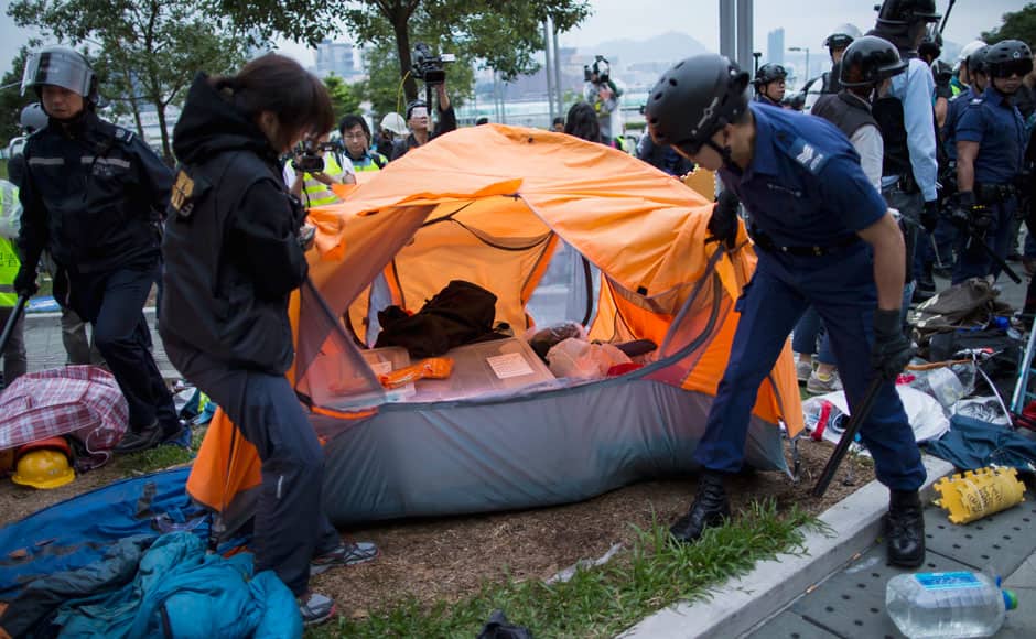 Police officers check a tent as they attempt to clear a demonstration site near the office of the Chief Executive in Hong Kong December 1,2014. Hong Kong police baton-charged and pepper-sprayed thousands of pro-democracy demonstrators in the early hours of Monday who were trying to encircle government headquarters, defying orders to retreat after more than two months of protests. REUTERS